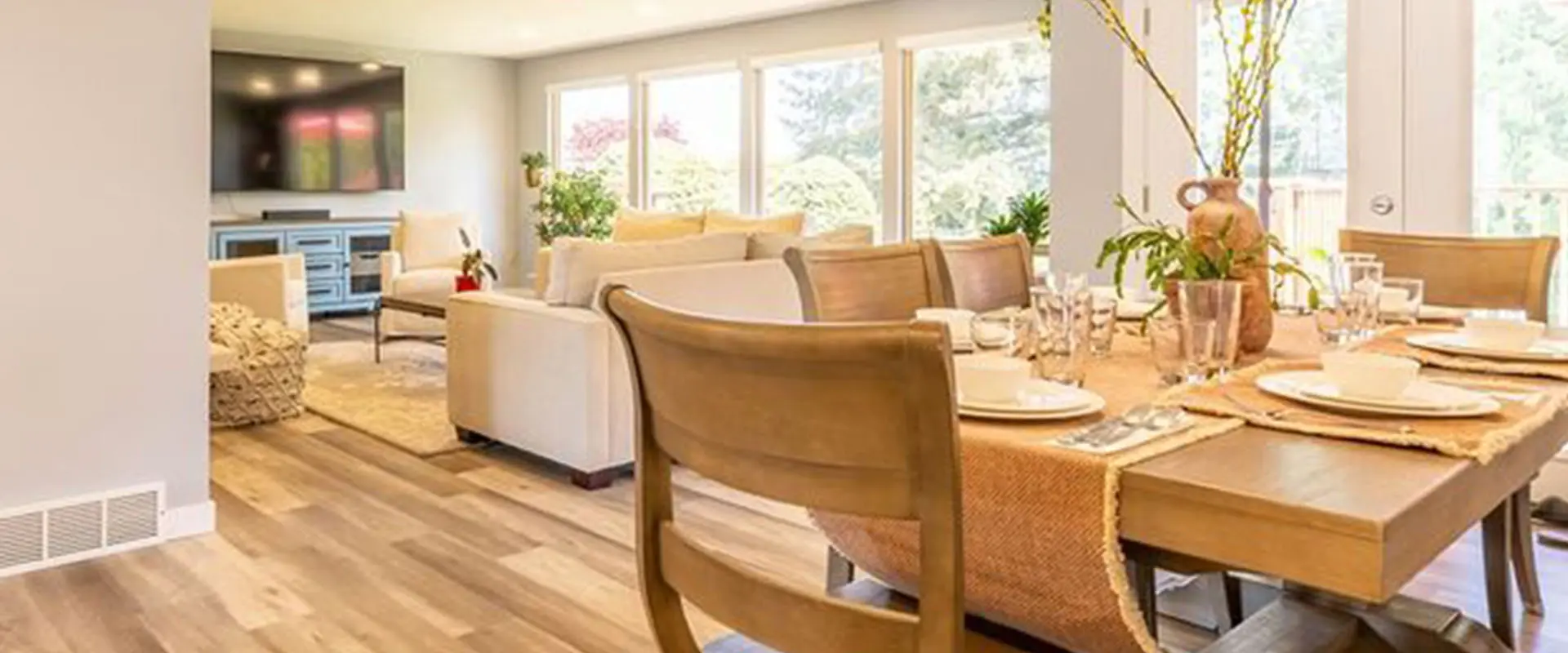 A dining room table with chairs and a couch in the background.