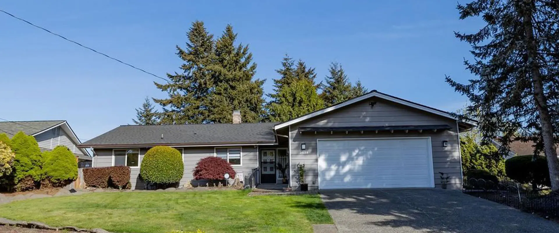 A house with trees in the background and a lawn.