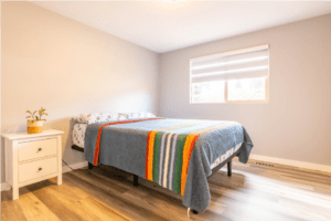 A bed room with a neatly made bed and a window