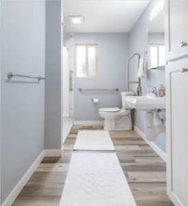 A bathroom with wood floors and white walls.